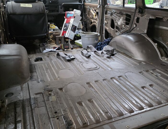 Stripped rear cargo area of 1987 Toyota Land Cruiser FJ60 prepped for restoration