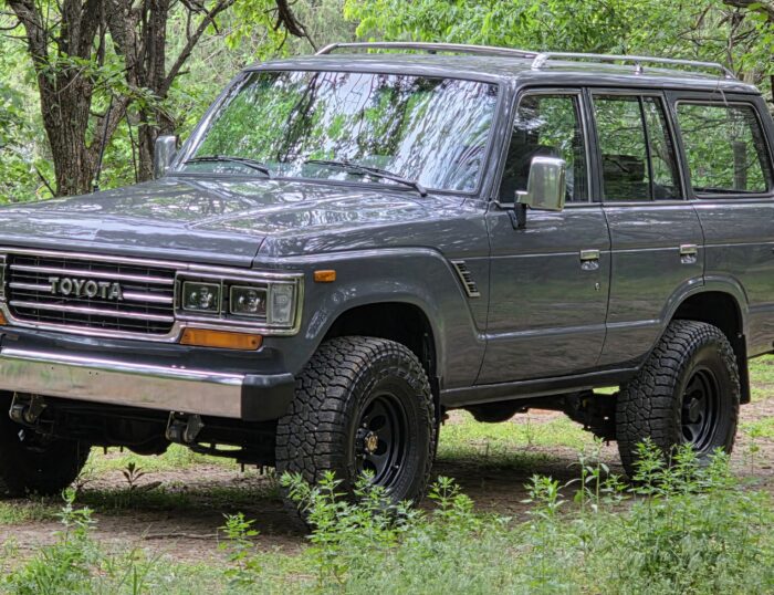 1989 Toyota Land Cruiser FJ62 V8 restomod in gray, front three-quarter view, restored by Land Cruiser Restorations