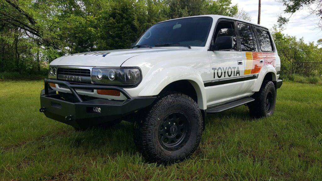 White Toyota 80 Series Land Cruiser with retro Toyota stripe livery and custom front bumper restored by Land Cruiser Restorations