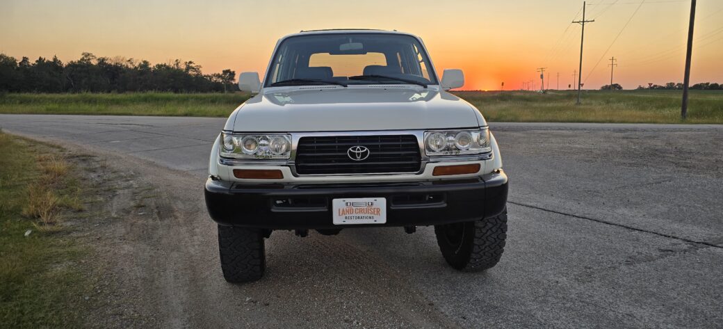 1995 FZJ80 Toyota Land Cruiser restored by Land Cruiser Restorations, front view in white over black two-tone at sunset