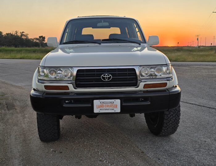1995 FZJ80 Toyota Land Cruiser restored by Land Cruiser Restorations, front view in white over black two-tone at sunset