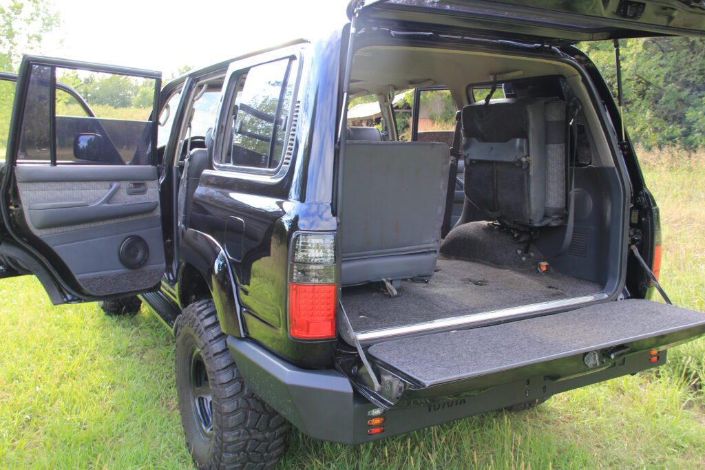 Black HDJ80 rear hatch open showing jump seats