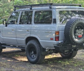Custom Toyota Land Cruiser FJ60 in Destroyer Gray with roof rack, rear bumper, and swing-out tire carrier