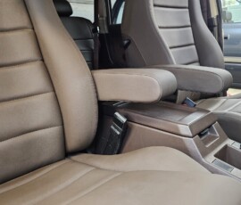 Custom Toyota Land Cruiser FJ60 interior with tan leather seats, center console armrest, and custom upholstery