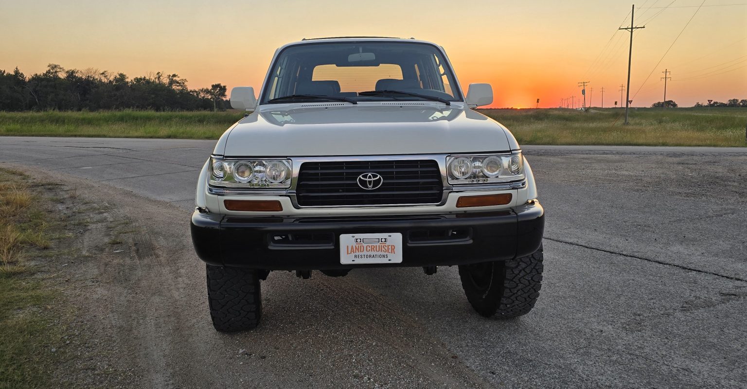 1995 FZJ80 Toyota Land Cruiser restored by Land Cruiser Restorations, front view in white over black two-tone at sunset